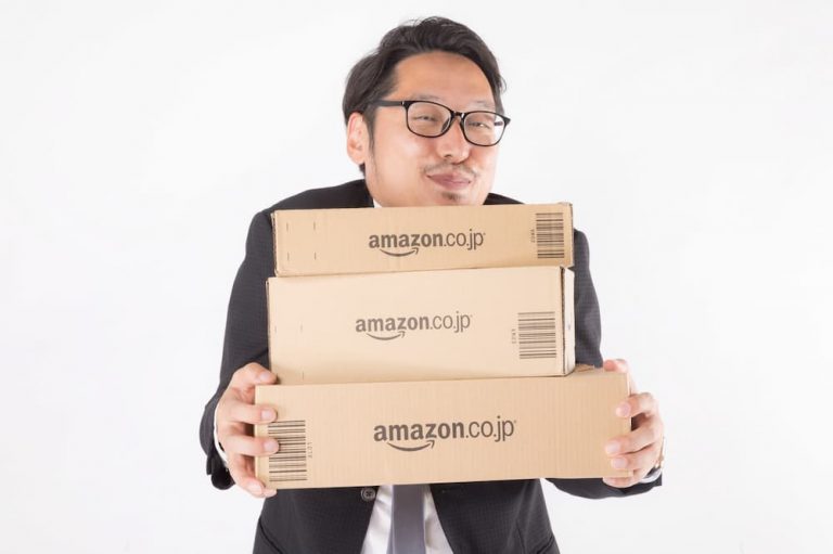 Amazonの箱を持ってニヤける男性