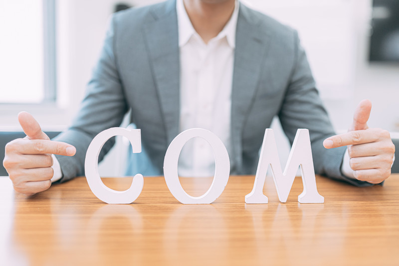 「COM」を指差す男性