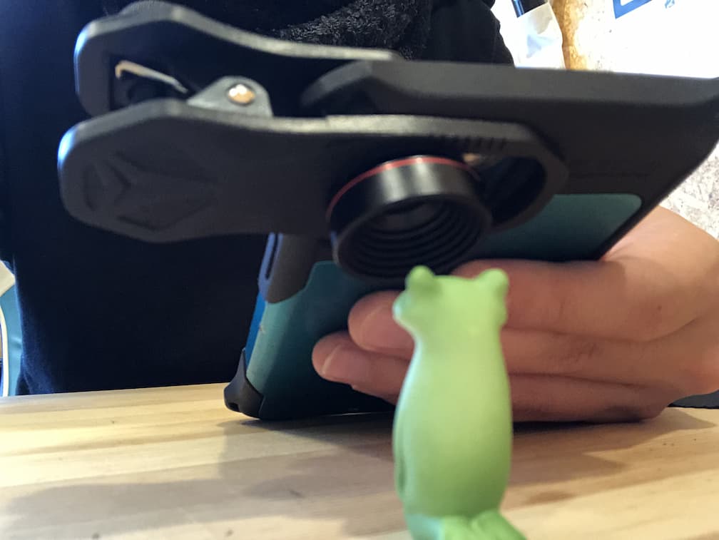 カエルの人形をiPhone+Selvimマイクロレンズ（25倍）で撮影する様子