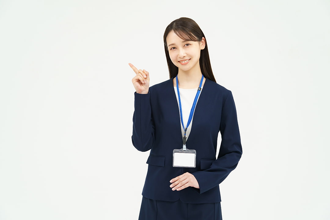 人差し指で左斜め上を指差すスーツを着た女性